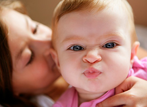 Mutter küsst Neugeborenes